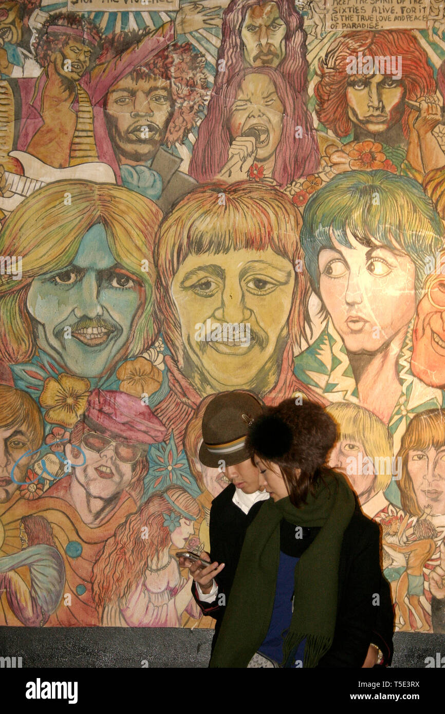 Young couple in front of famous musicians' wall mural by Rico Fonseca
