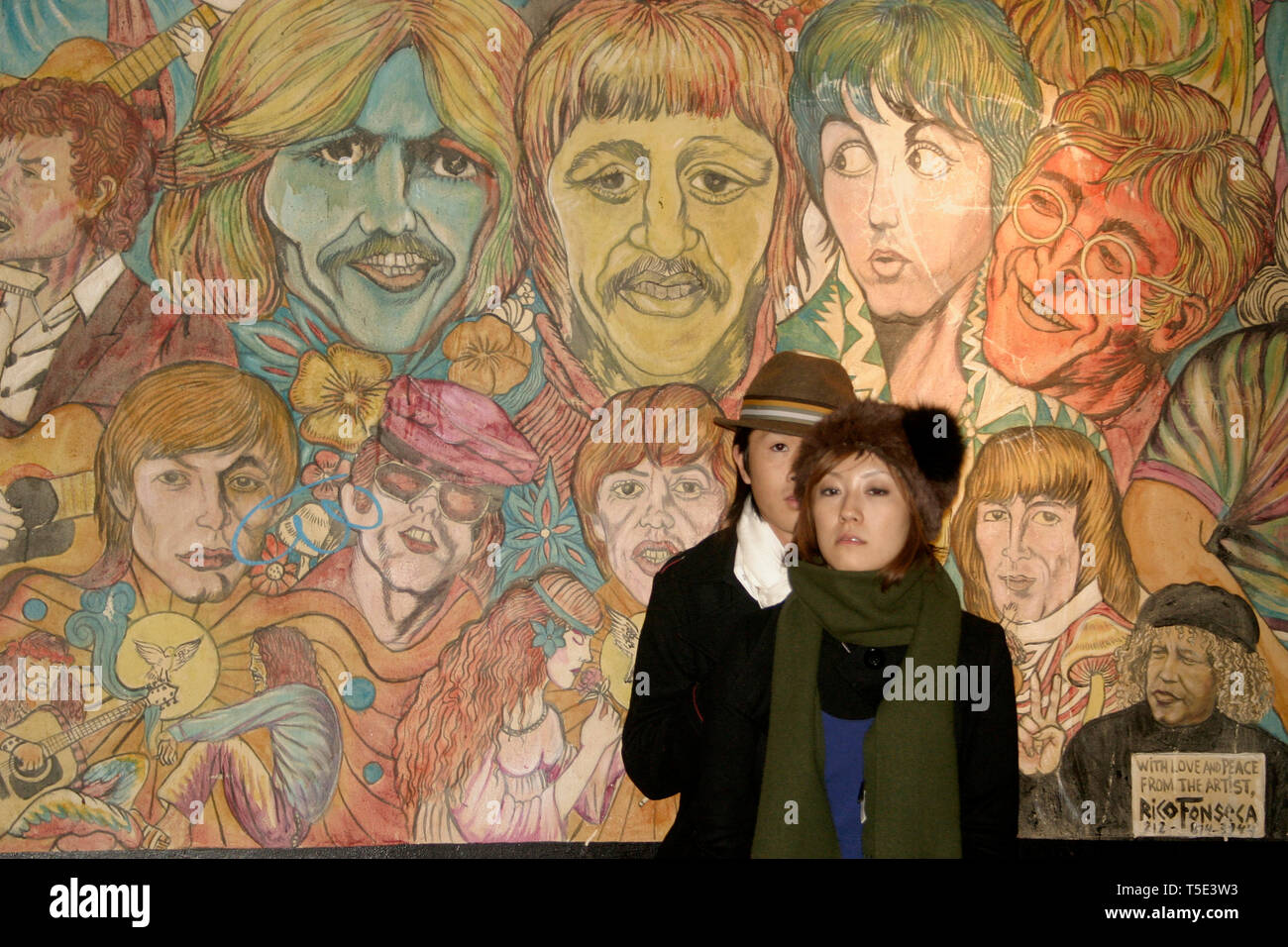 Young couple in front of famous musicians' wall mural by Rico Fonseca