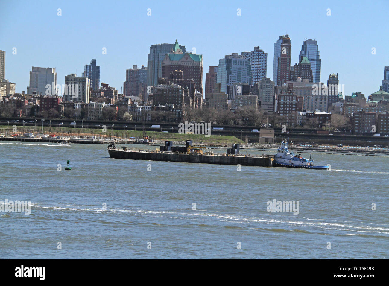 Tugboat on the New York Bay, with view of buildings in the Lower