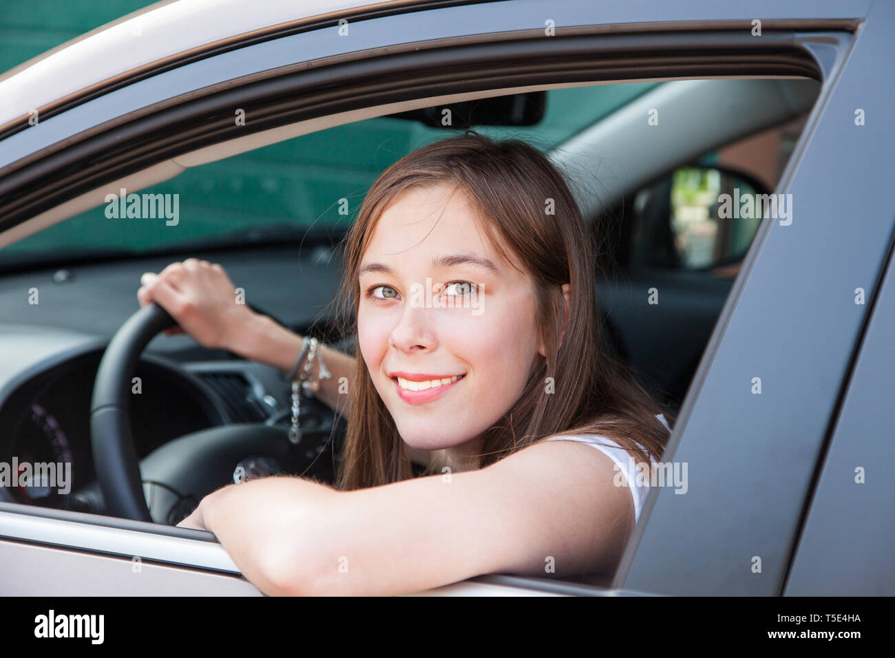 A teenage girl drives in a car Stock Photo