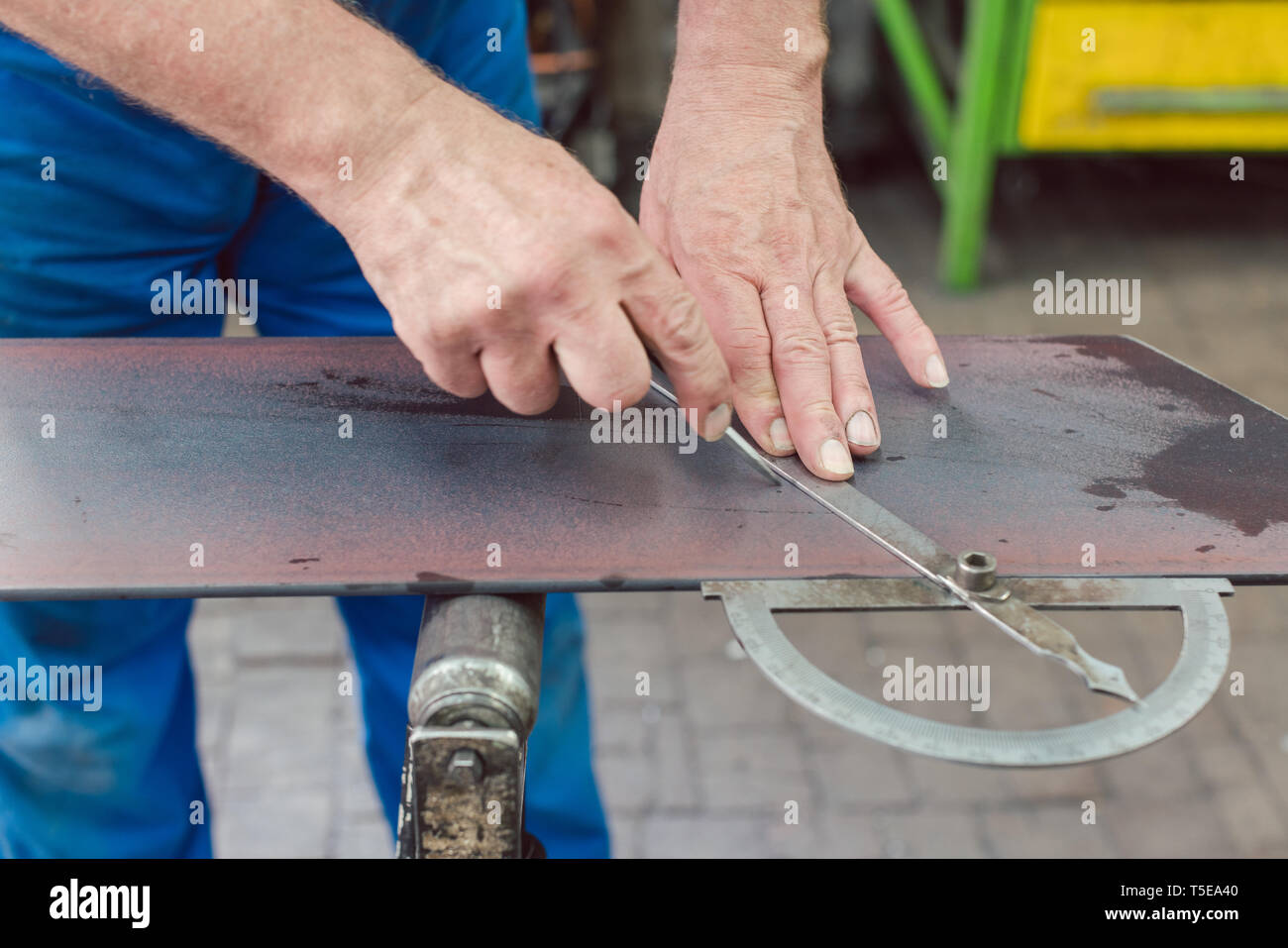 Metalworker with angle meter measuring strip of metal Stock Photo