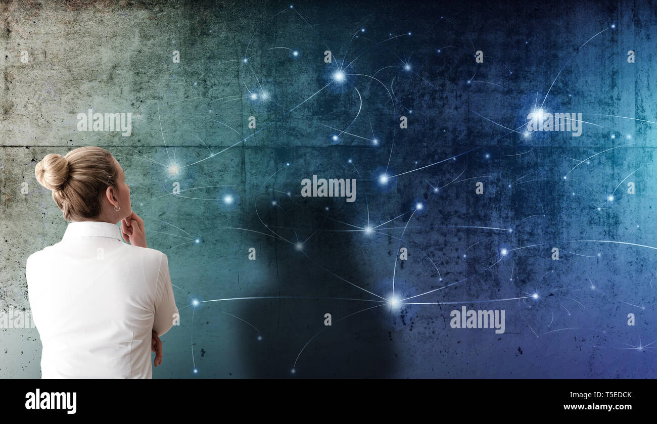 rear view of blonde woman looking at projection of network structure with glowing nodes on rough concrete wall, social network technology concept Stock Photo