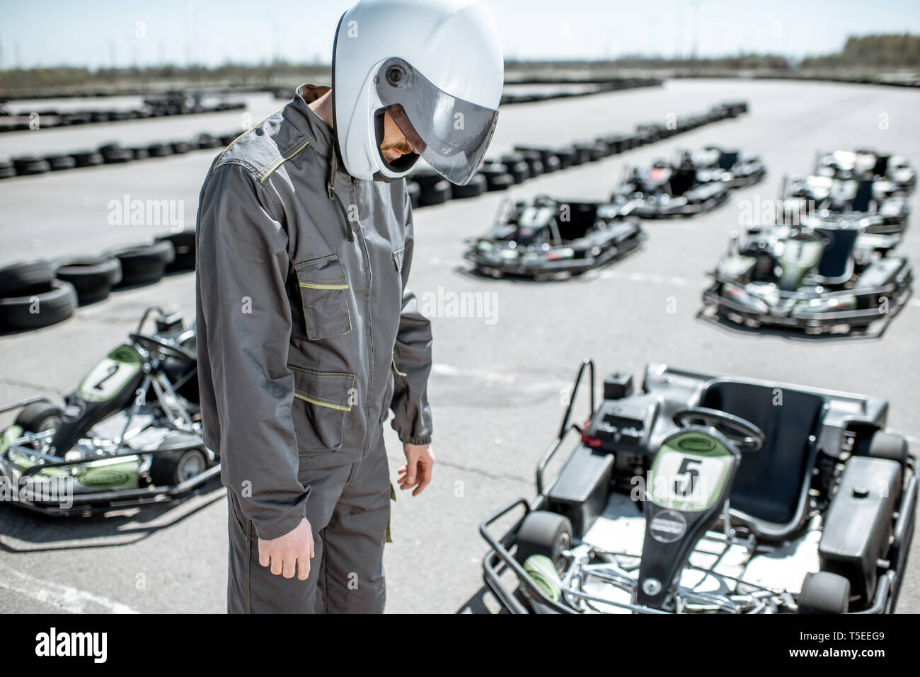 Despair racer in sportswear feeling sad standing as a loser on the go-kart  track outdoors Stock Photo - Alamy