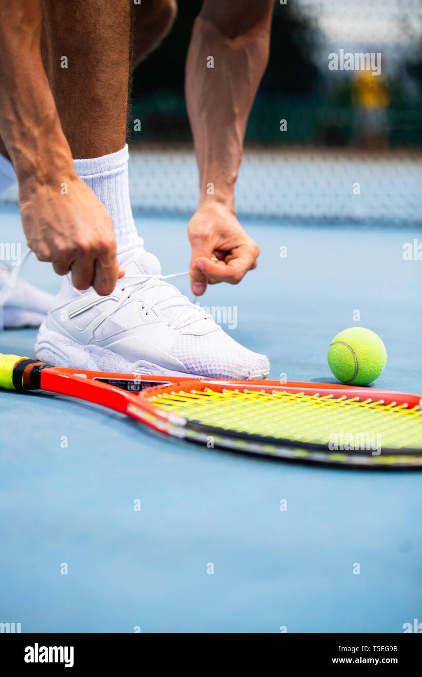 Tennis athlete player getting ready tying shoe laces during game on outdoor Stock Photo Alamy