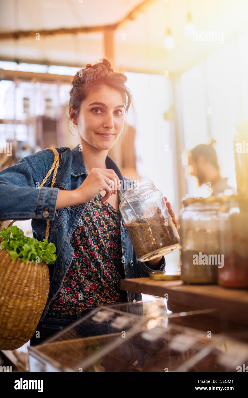 Beautiful young woman shopping in a bulk food store Stock Photo