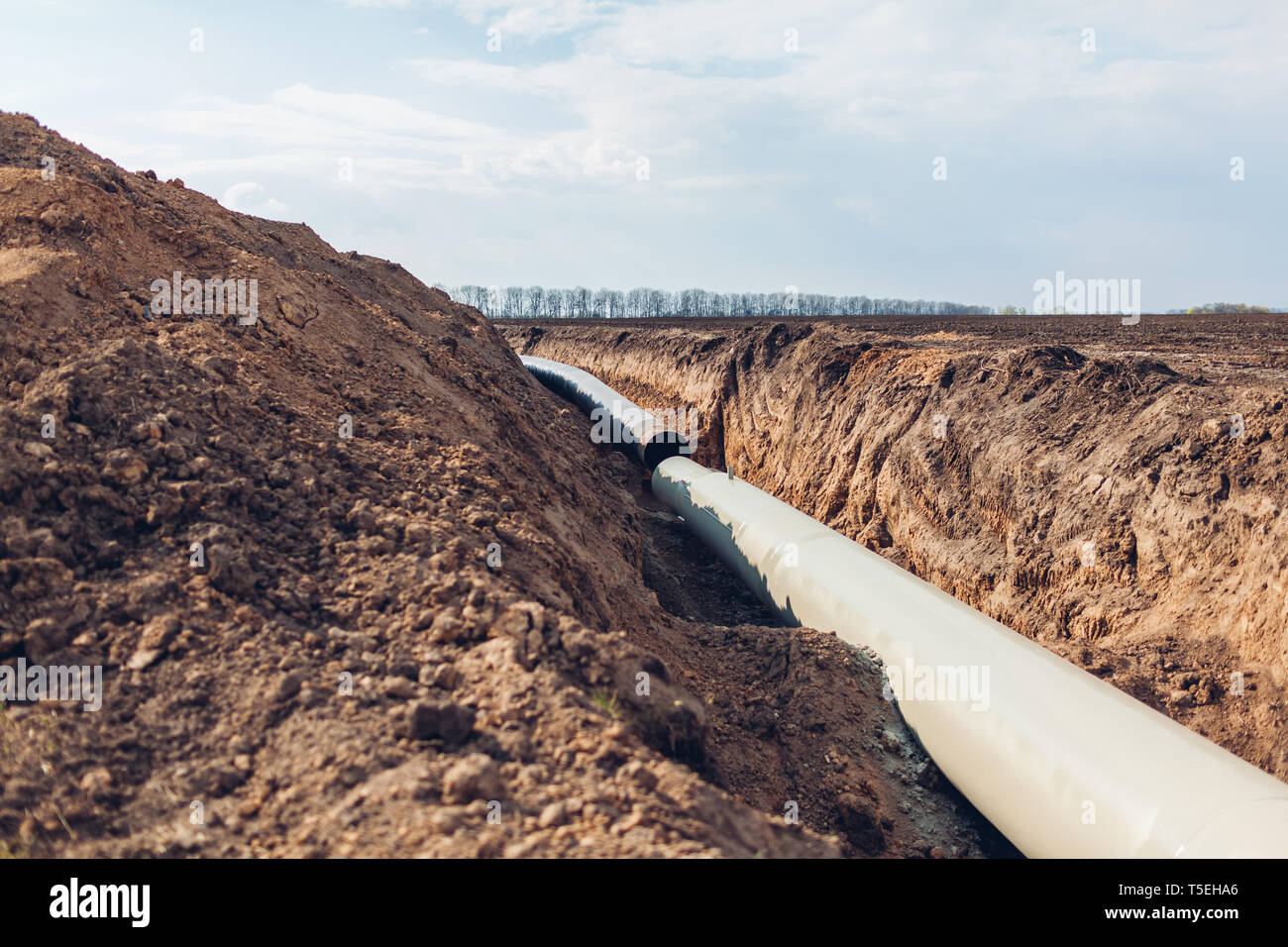 Industrial gas pipeline. Laying new pipes in field underground. Outdoor construction Stock Photo