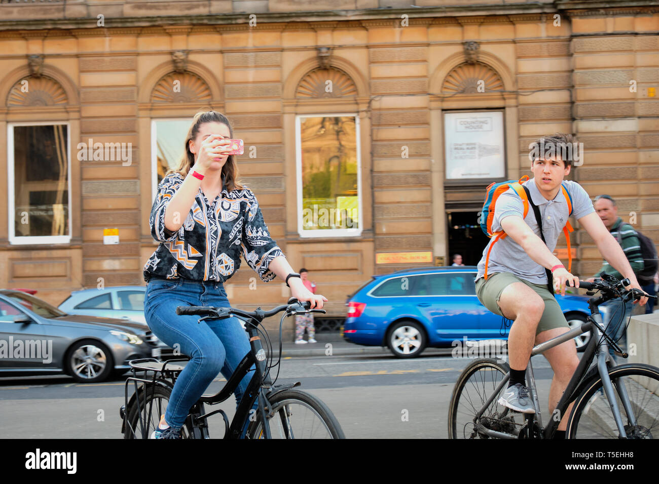 The girl with the phone goes on a bike Glasgow on 21 April 2019 Stock Photo