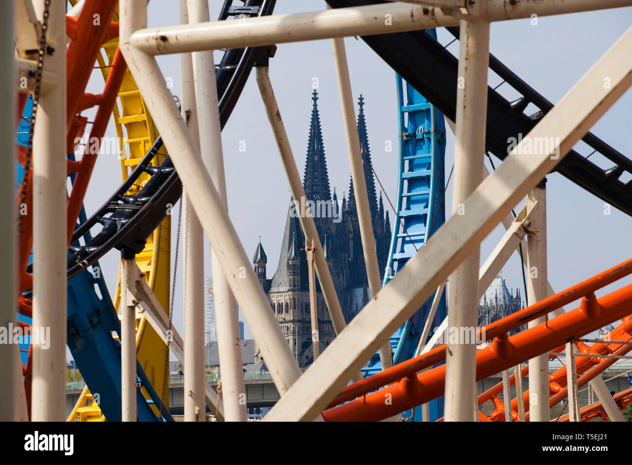 roller coaster with loops on the fair on the banks of the river Rhine in the town district Deutz, view to the cathedral, Cologne, Germany.  Achterbahn Stock Photo