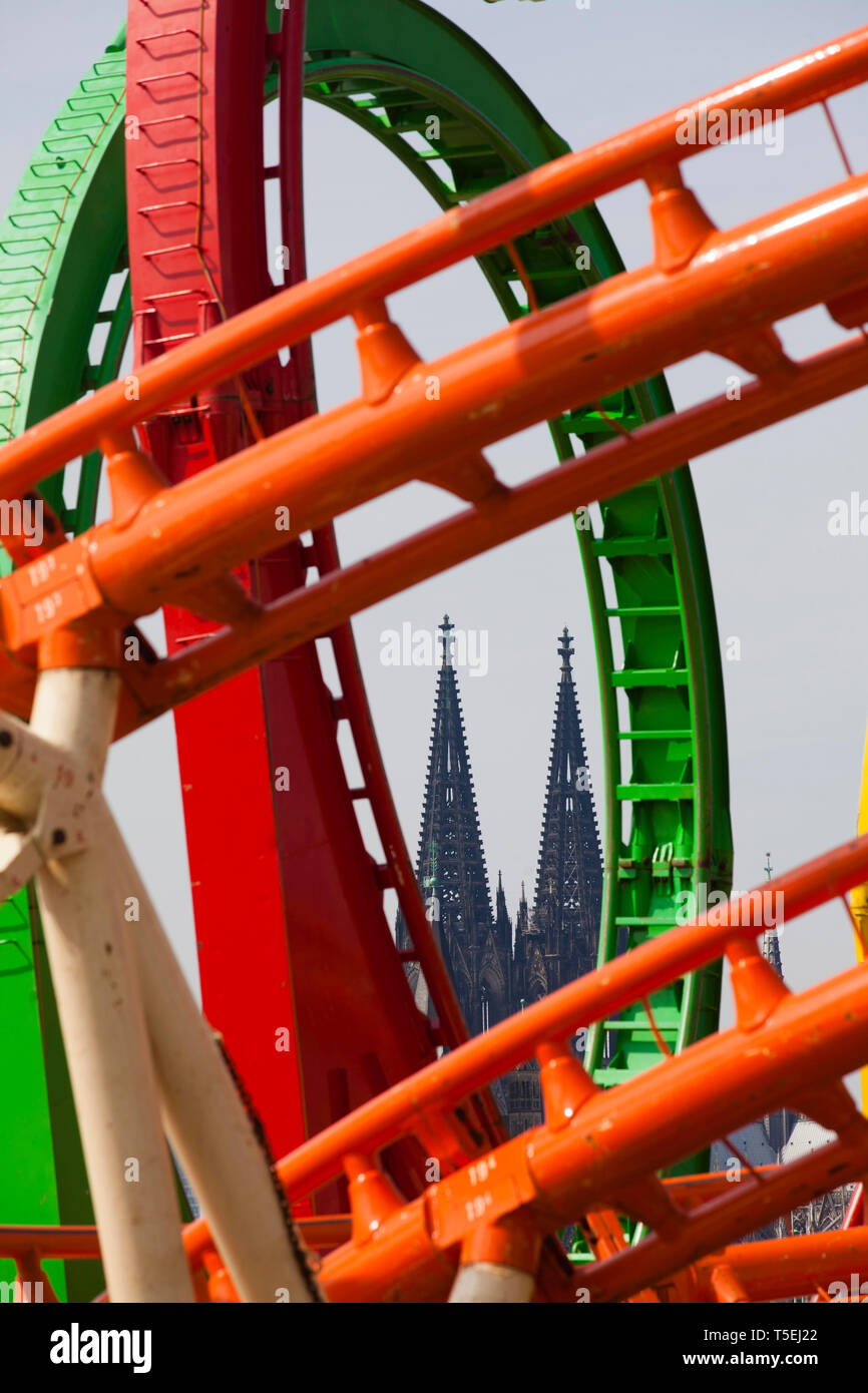 roller coaster with loops on the fair on the banks of the river Rhine in the town district Deutz, view to the cathedral, Cologne, Germany.  Achterbahn Stock Photo