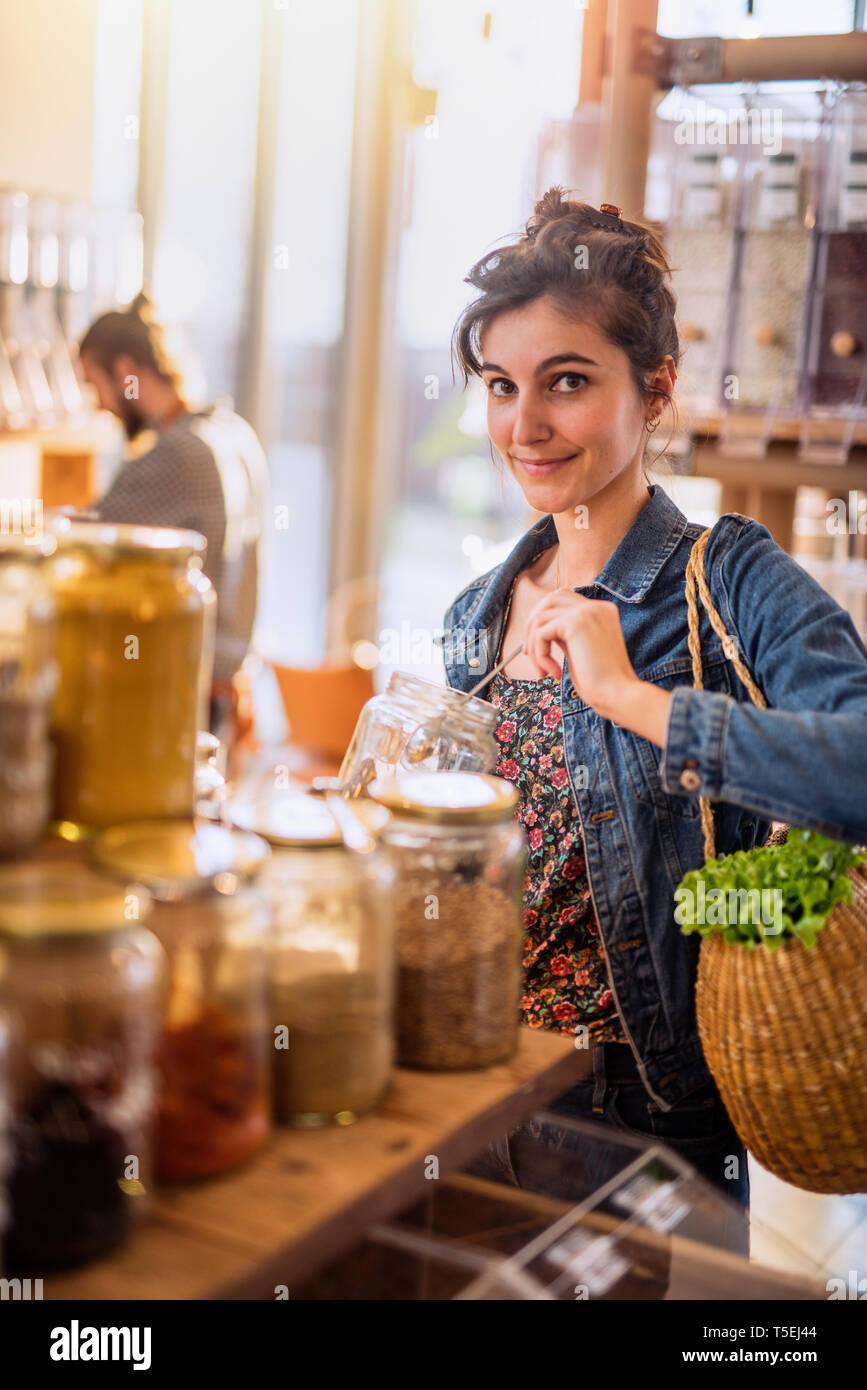 Beautiful young woman shopping in a bulk food store Stock Photo