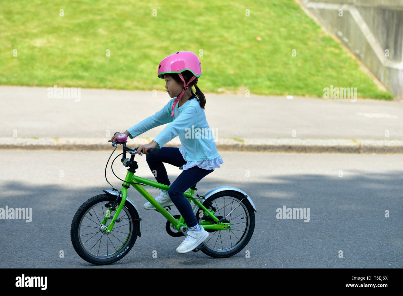 Youg asian girl on green bicycle, Kensington Gardens, London, United Kingdom Stock Photo