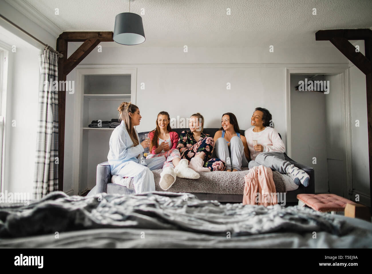 Small Group Of Female Friends Sitting In A Bedroom On A Weekend Away They Re Relaxing In Their Pyjamas And Talking Stock Photo Alamy