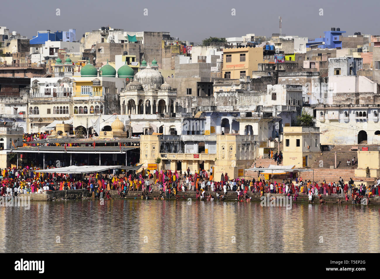 Devout Hindus bathe in a holy ghat to wash away their sins, thereby earning themselves a place in Swarga (heaven). Pushkar Lake, Rajasthan, India. Stock Photo