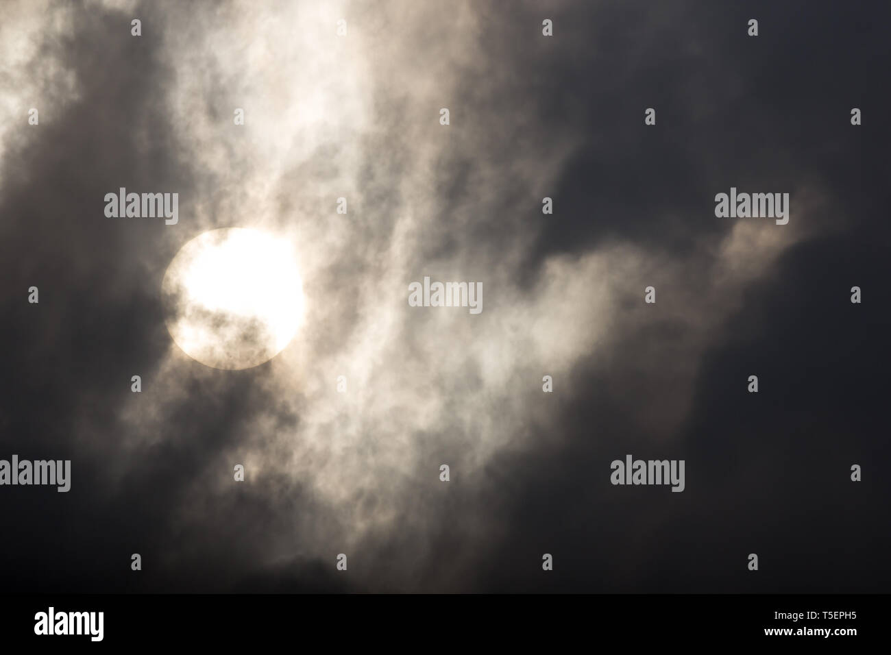 the sun hide behind grey cloud on evening Stock Photo