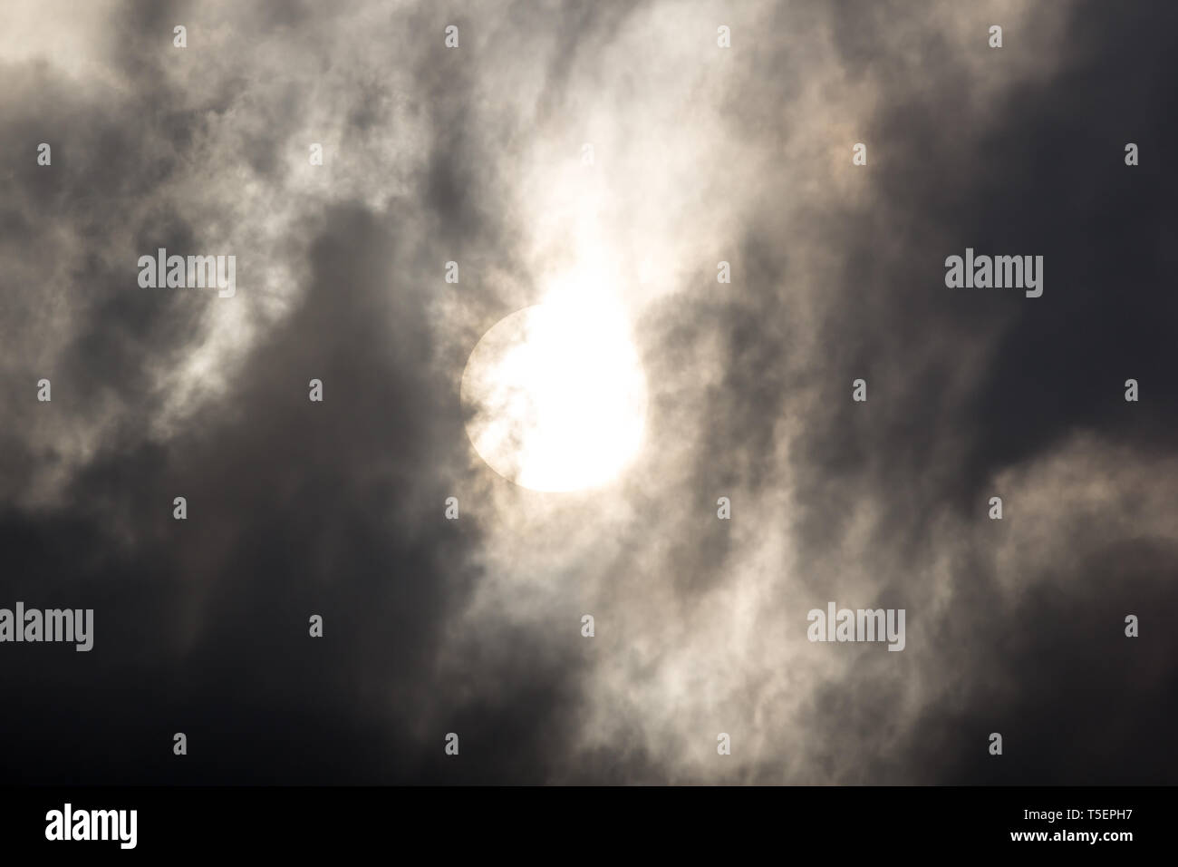 the sun hide behind grey cloud on evening Stock Photo