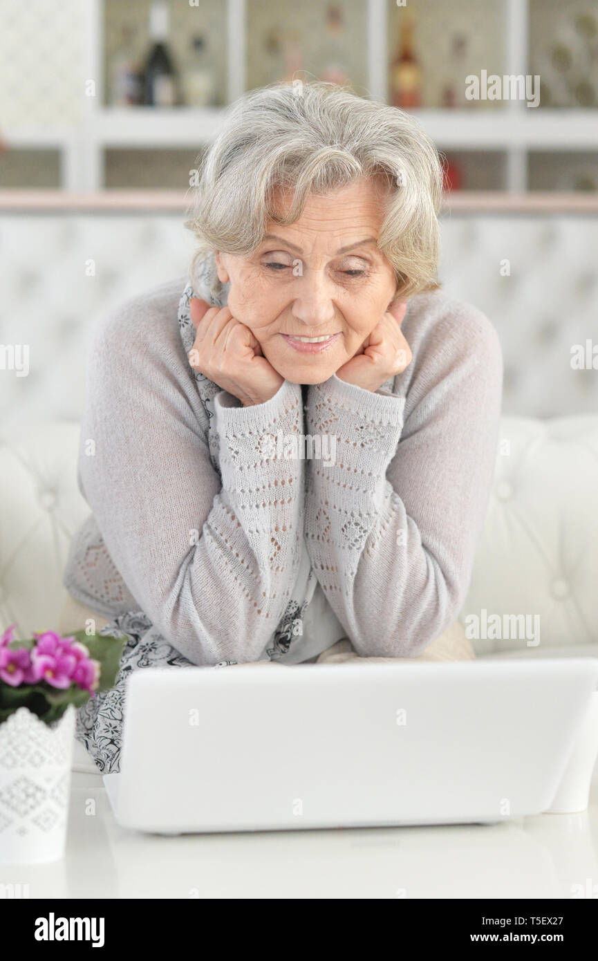 Senior woman using laptop while sitting on sofa Stock Photo