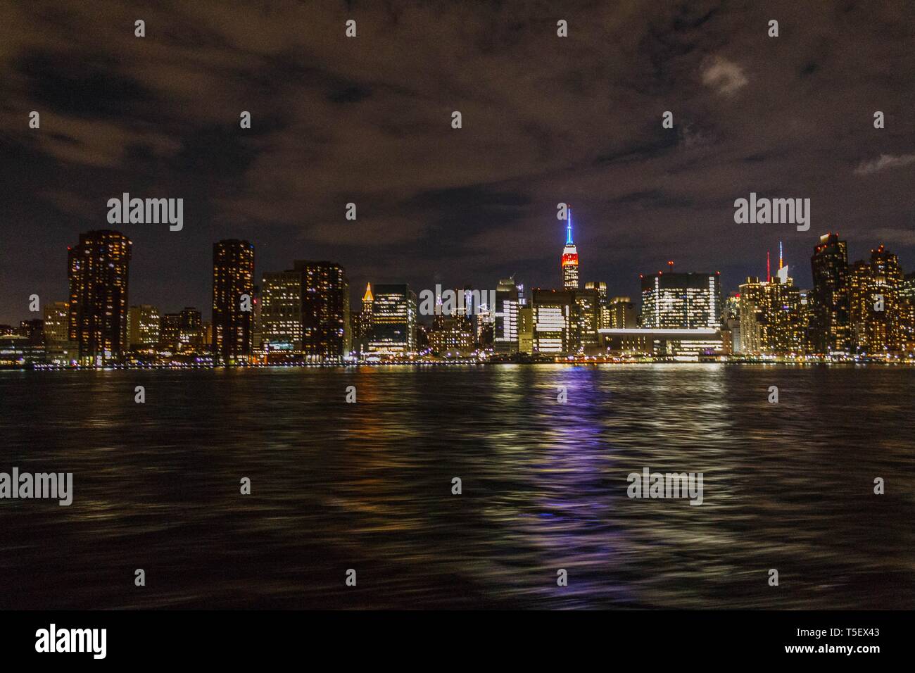Manhattan at night shot from afar with river reflection Stock Photo - Alamy