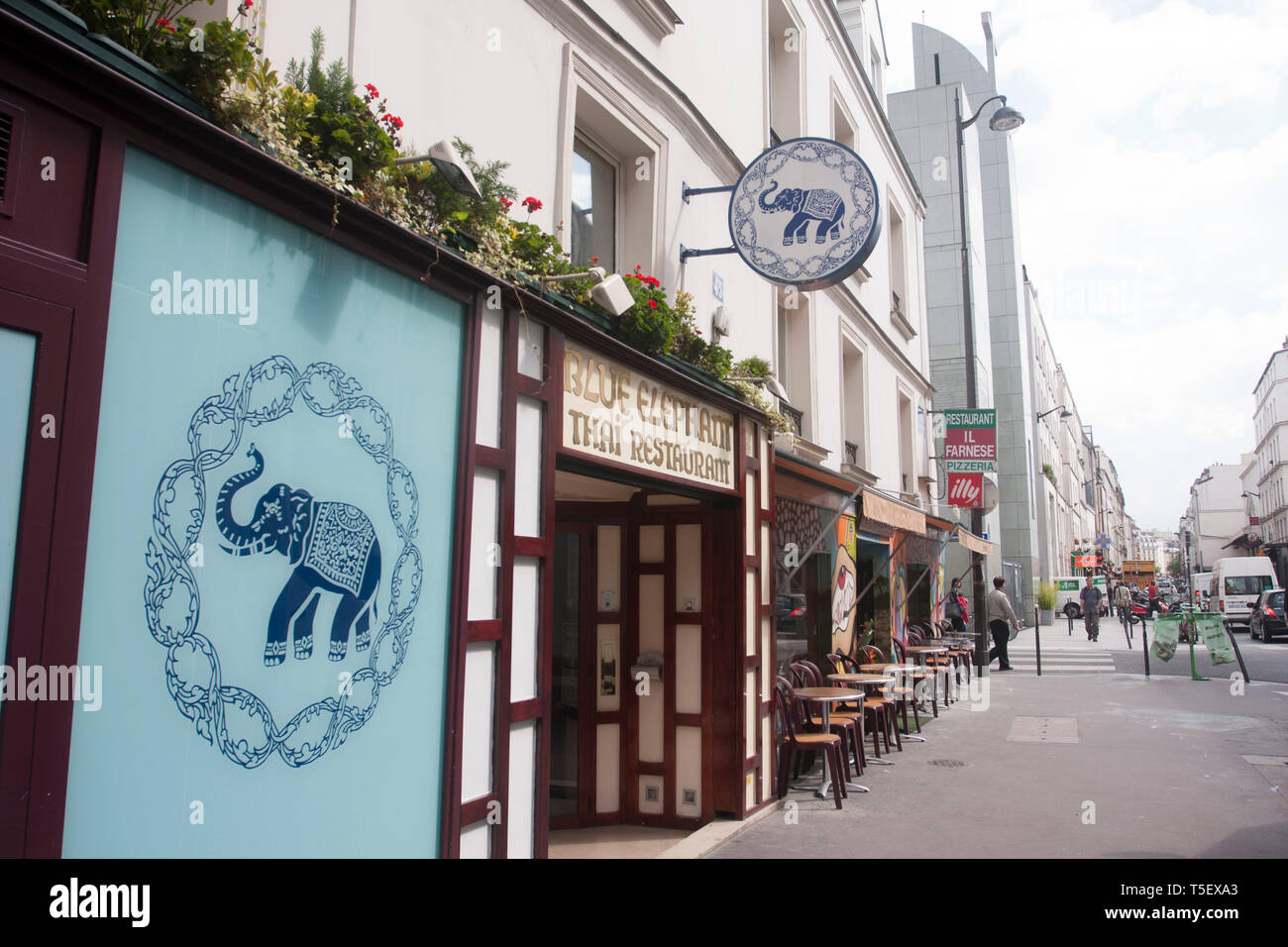 View of a footpath in Paris with the front of a Thai food restaurant at the foreground. Stock Photo