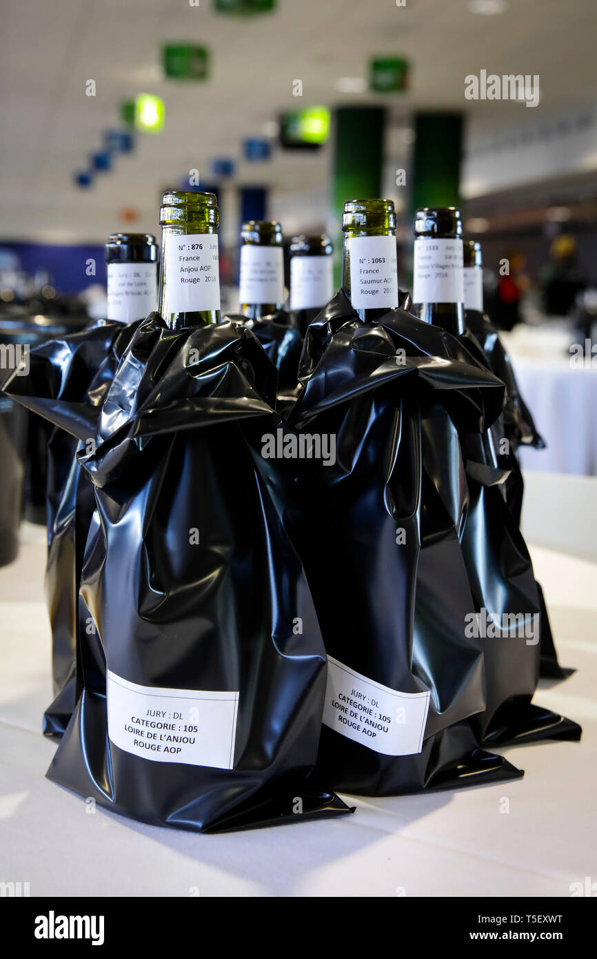 Illustration, blind wine tasting contest: bottles of wine with a black sleeve to hide the label Stock Photo