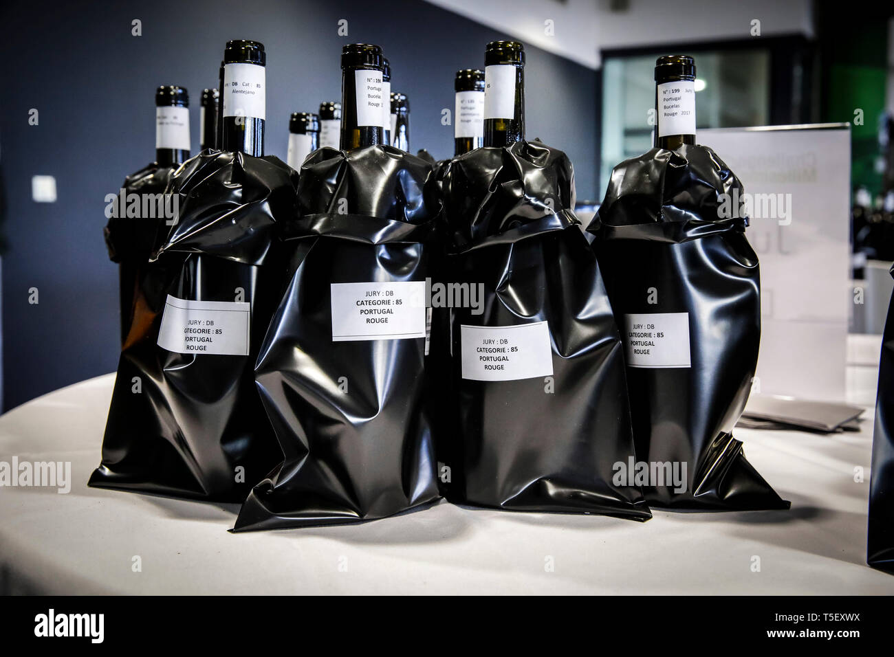 Illustration, blind wine tasting contest: bottles of wine with a black sleeve to hide the label Stock Photo