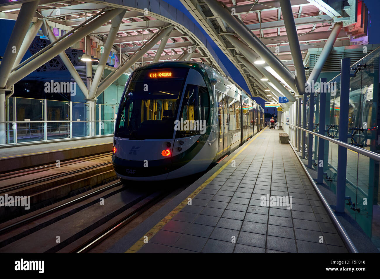 A light rail train pulls into a station at night, part of the Kaohsiung MRT system. Stock Photo