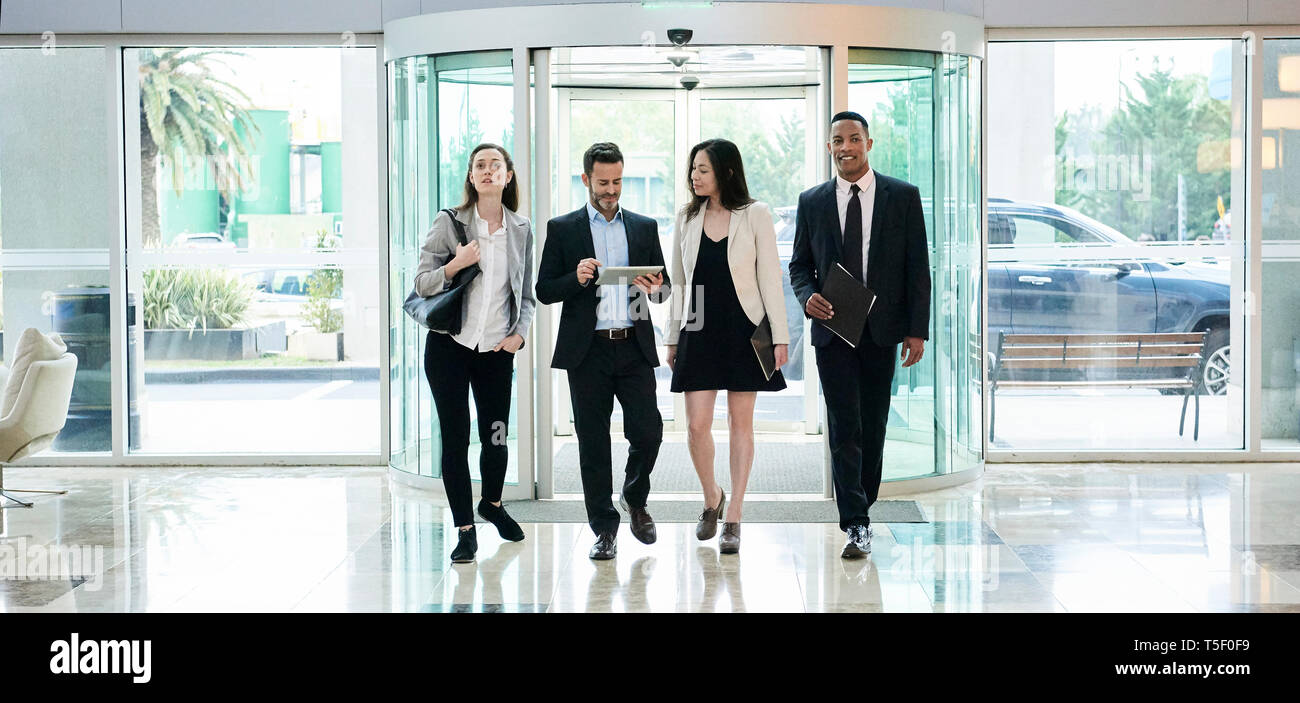 Business people talking while entering in hotel lobby Stock Photo - Alamy