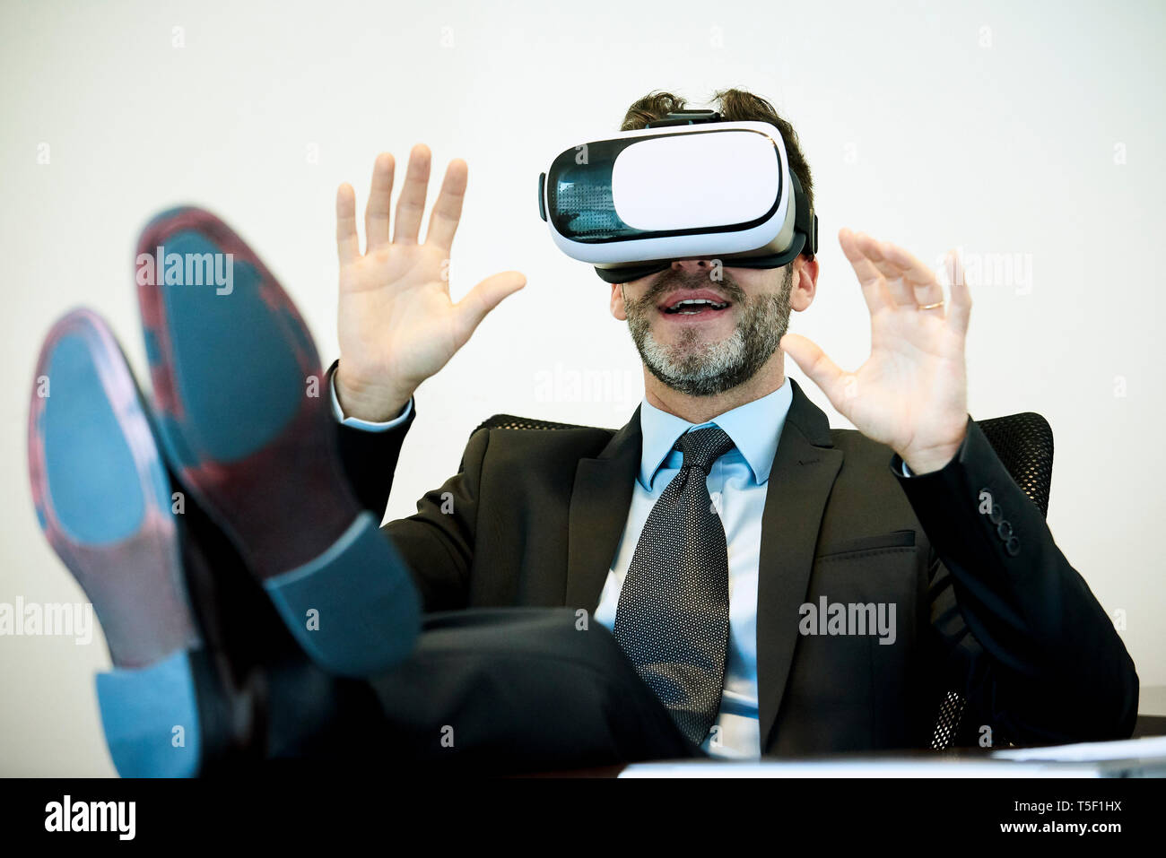 Businessman using virtual reality headset in office Stock Photo
