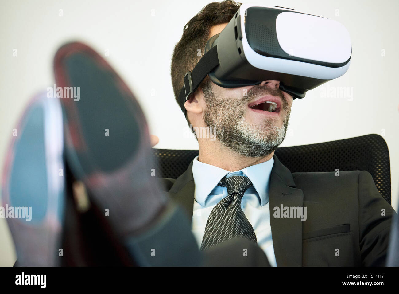 Businessman using virtual reality headset in office Stock Photo