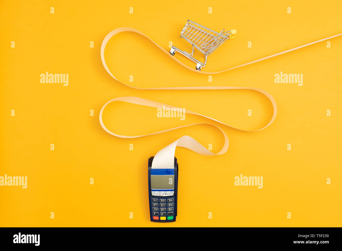 Miniature empty shopping cart on a long POS terminal receipt, expensive