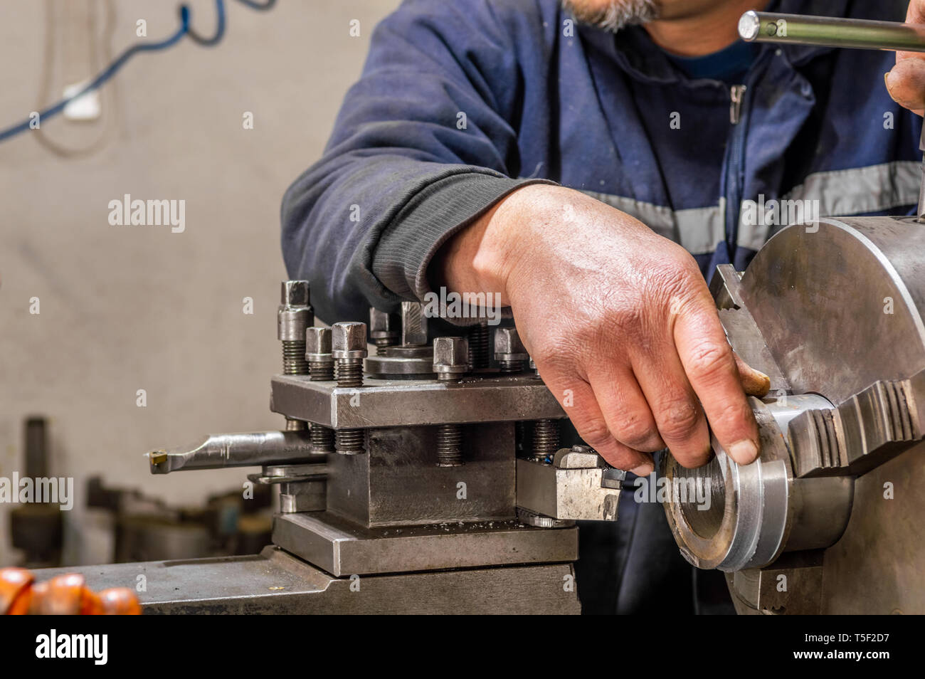 Blue collar Machine Operator Working With Lathe Machine In A Factory