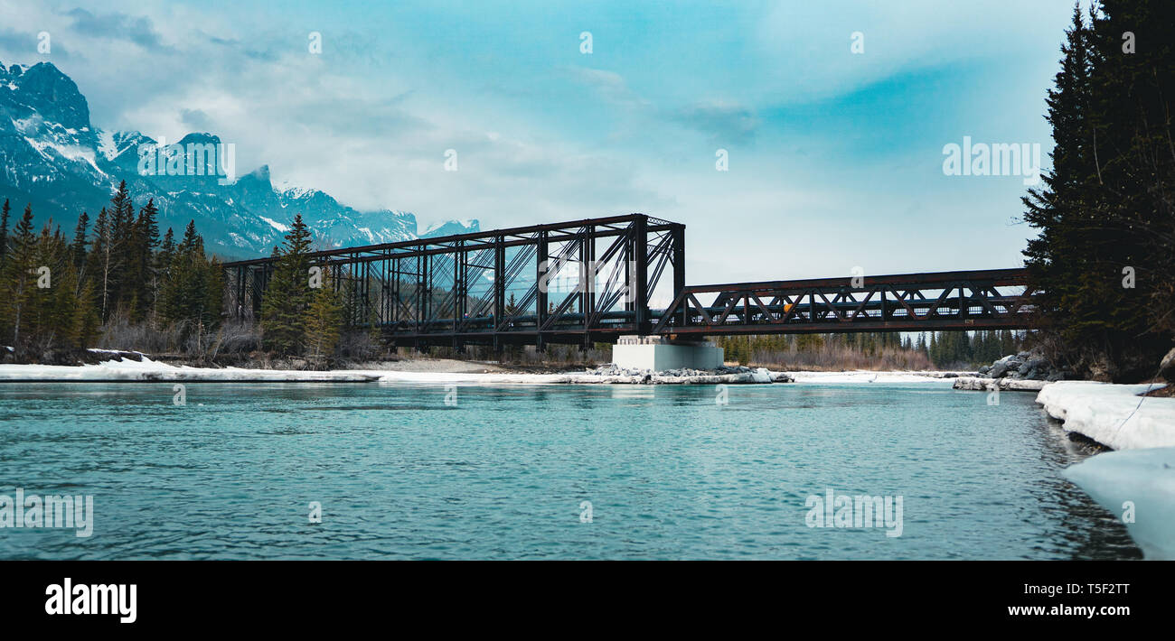 Historic Canmore Engine Bridge is a truss bridge over the Bow River in the Canadian Rockies of Alberta. The bridge was built by the Canadian Pacific R Stock Photo