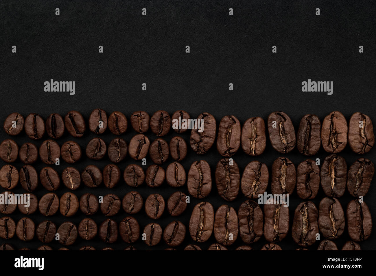 Roasted coffee beans on black background. Top view with space for your ...