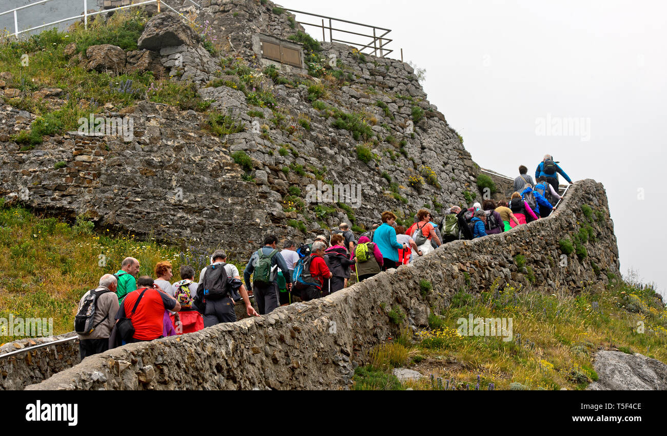 Group of visitors ascneding to the hermitage San Juan de Gaztelugatxe on the islet Gaztelugatxe near Bakio, Costa Vasca, Bay of Biscay, Basque Country Stock Photo