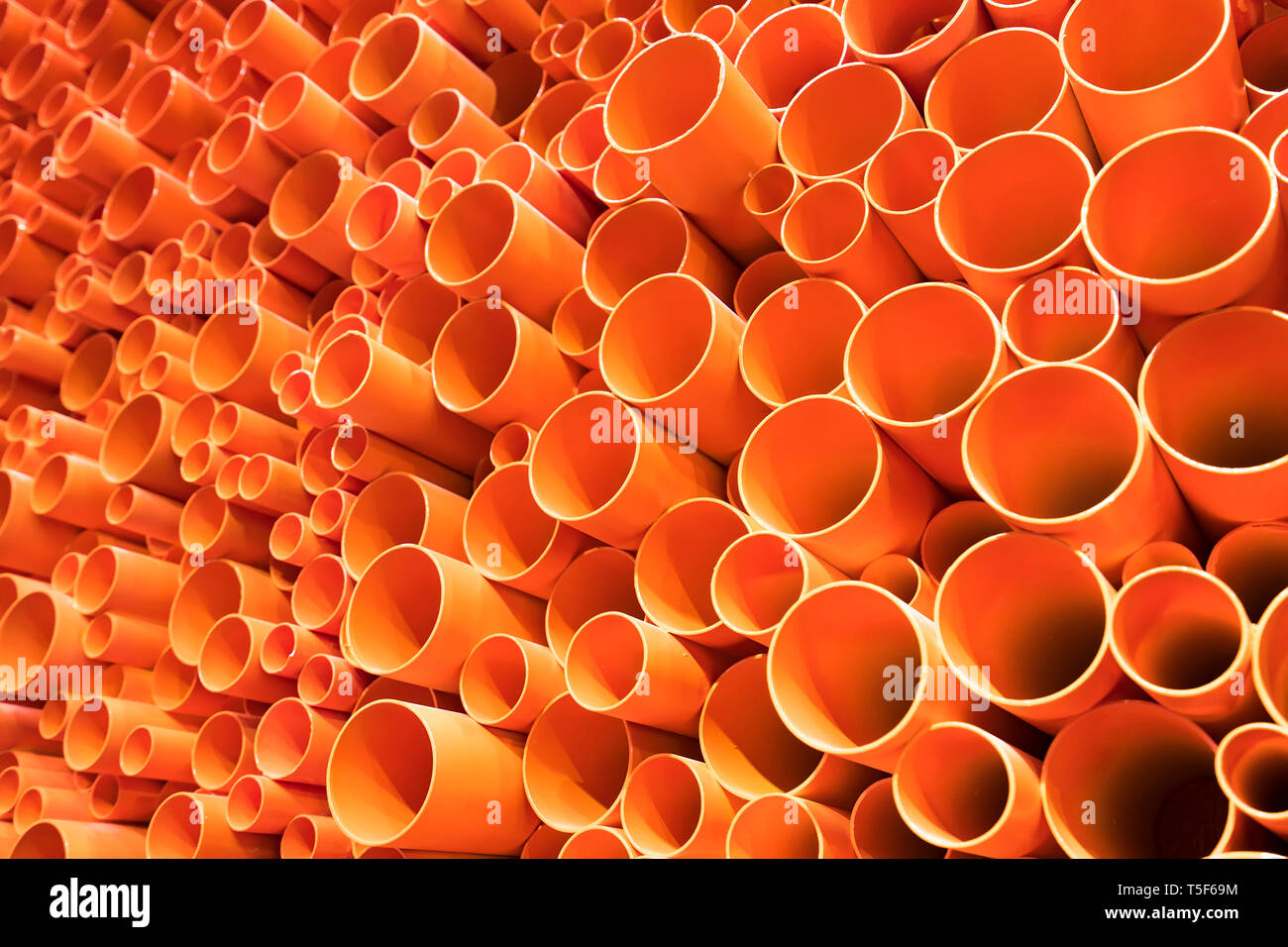 orange PVC pipes stacked in construction site Stock Photo