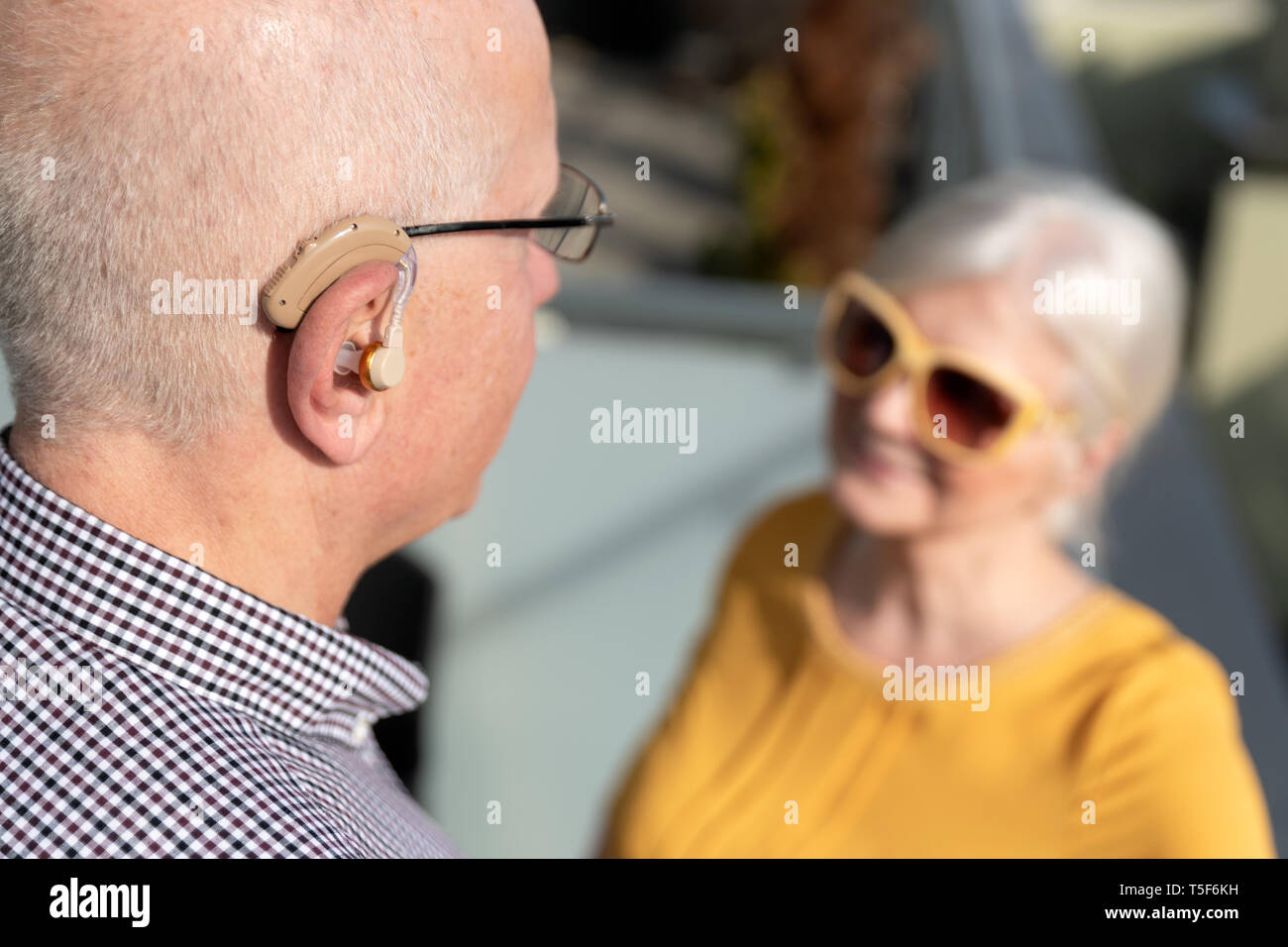 Elderly person holding hearing aid hires stock photography and images
