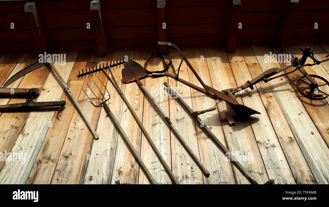 different old farmer tools on a wooden wall background Stock Photo - Alamy