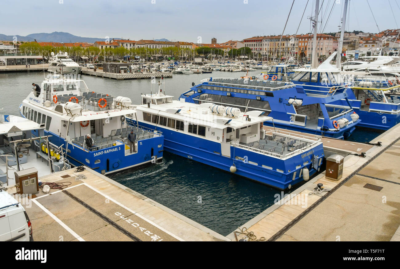 SAN RAPHAEL, FRANCE - APRIL 2019:  Small passenger ferries and sightseeing boats tied up in the harbour in San Raphael. A ferry is reversing Stock Photo