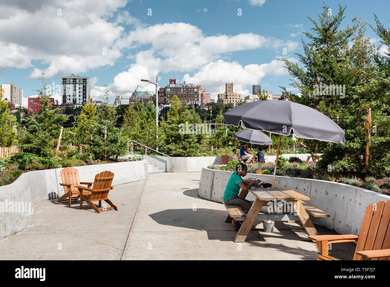 Moveable picnic tables and Adirondack chairs clustered to create seating areas. Brooklyn Bridge