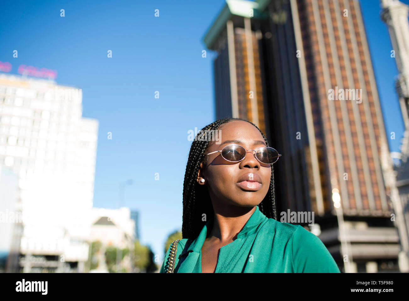 Black woman facing the sun while resting in a touristic spot of Madrid Stock Photo