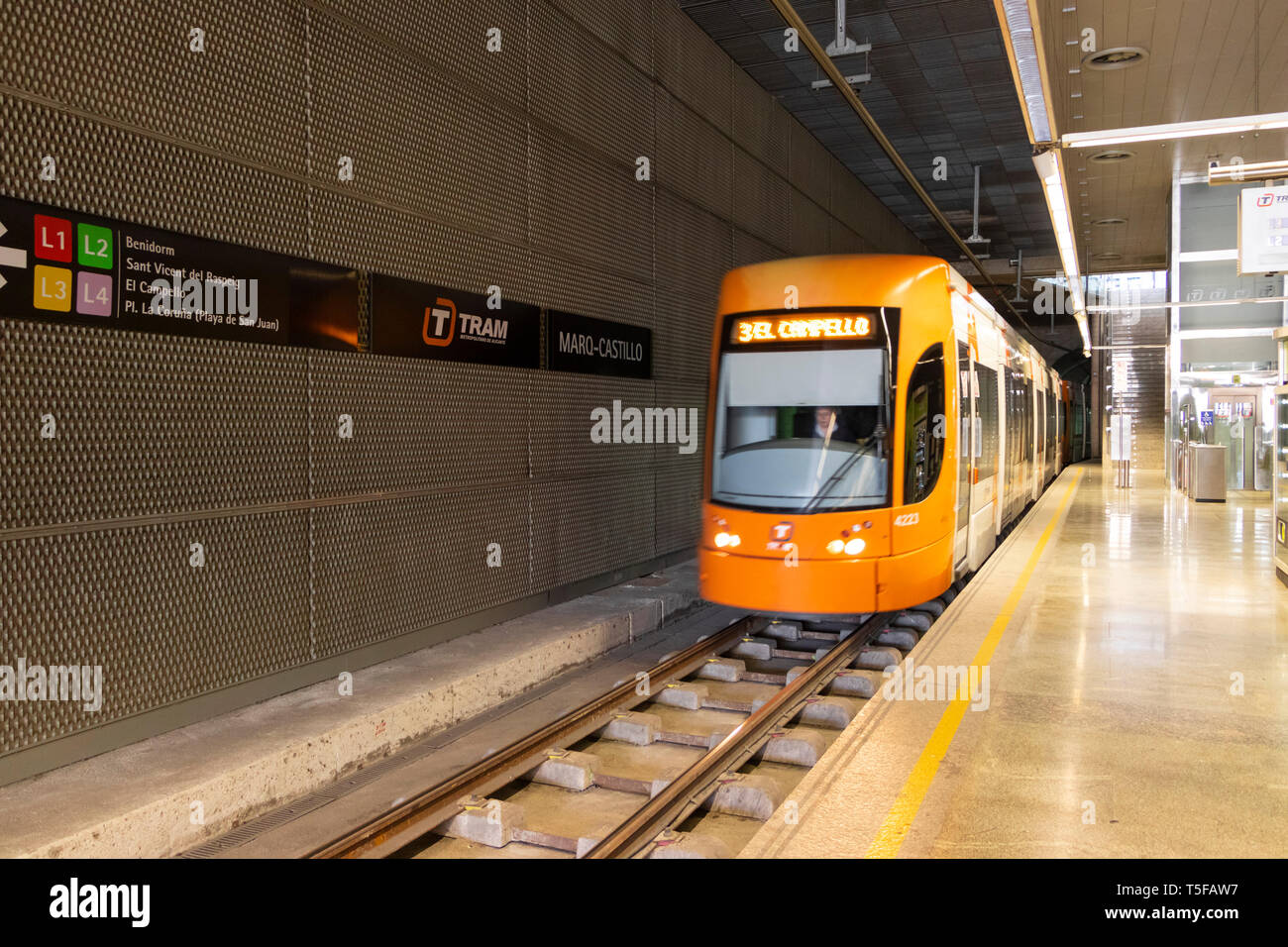 orange El Campello bound metro train speeds into Marq - Castillo rapid  transit rail station in Alicante spain Stock Photo - Alamy
