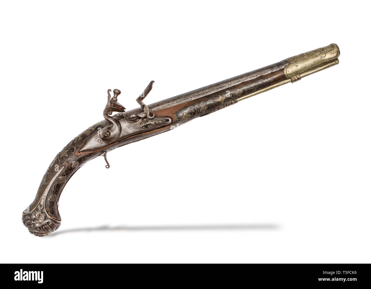 The 19th century Turkish flintlock pistol with silver and brass inlay over wooden stock. Stock Photo