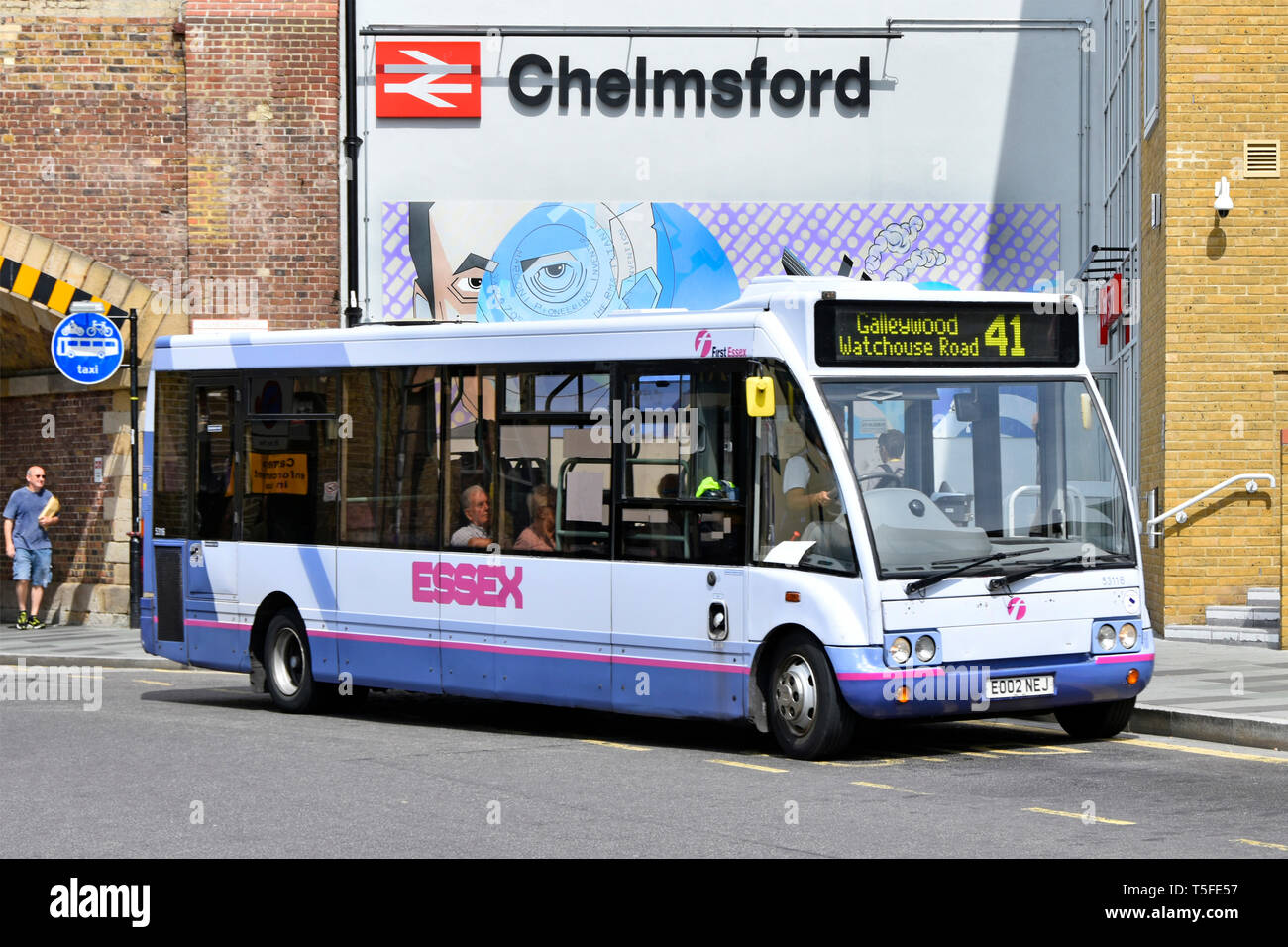 First Essex public transport single decker local passenger bus service & driver at bus stop outside Chelmsford train station entrance Essex England UK Stock Photo