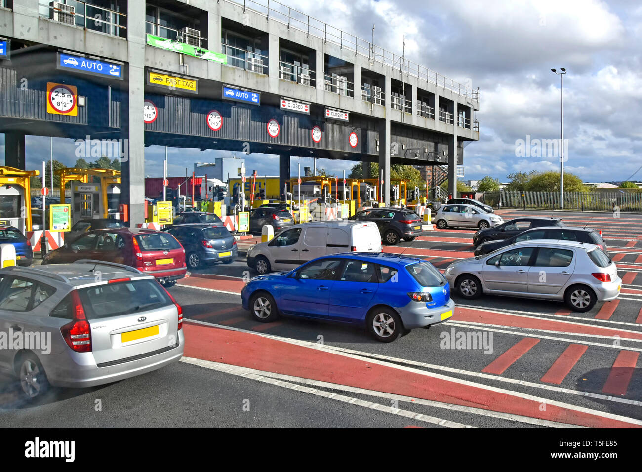 Short queues of traffic at toll booths on Wallasey side of Kingsway tunnel passing under River Mersey linking with Liverpool Merseyside England UK Stock Photo
