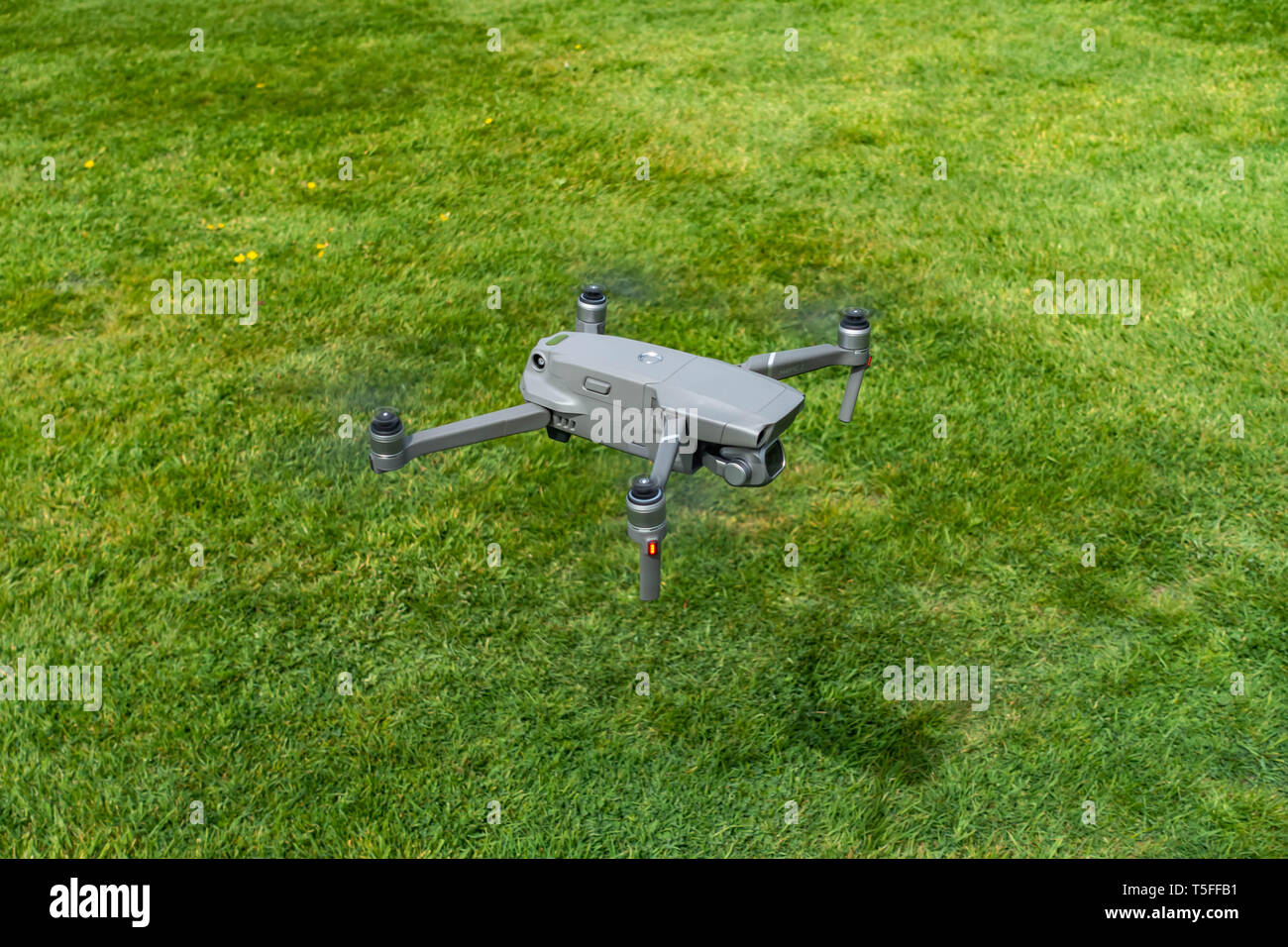 Birds eye view looking down onto a flying DJI Mavic 2 PRO personal Drone flying very low near to the ground Stock Photo