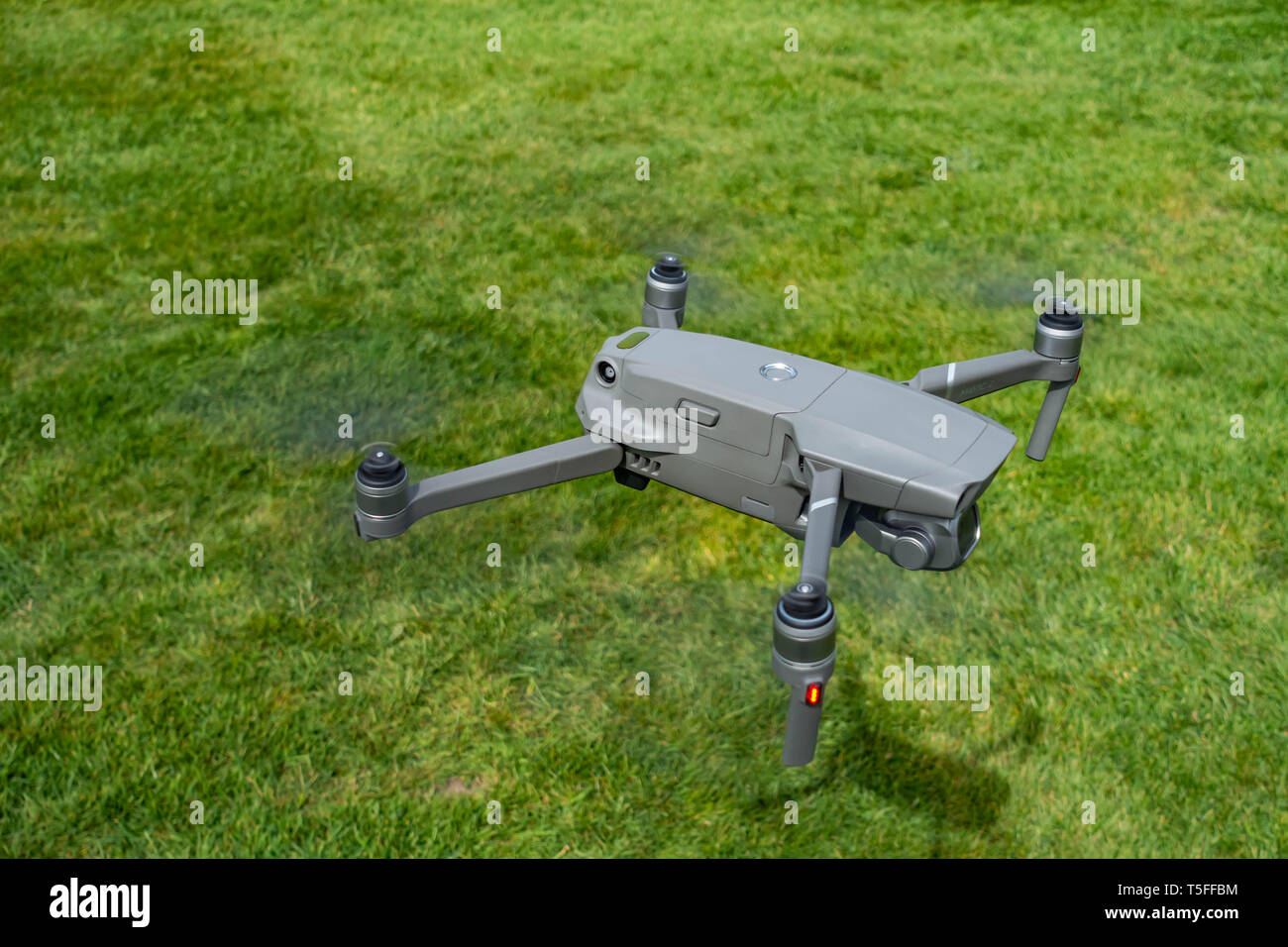 Birds eye view looking down onto a flying DJI Mavic 2 PRO personal Drone flying very low near to the ground Stock Photo