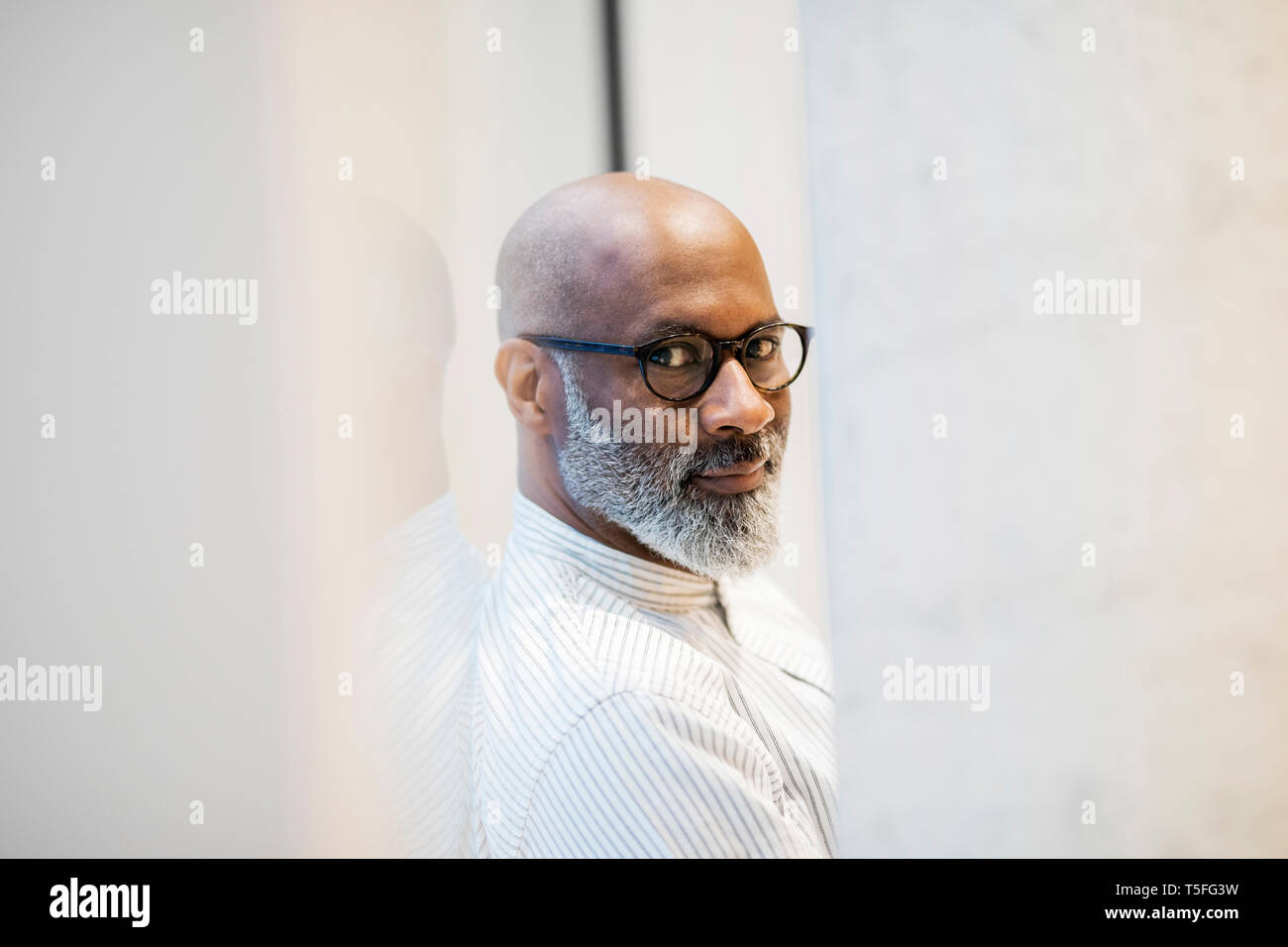 Portrait of bald mature businessman with grey beard wearing glasses Stock Photo