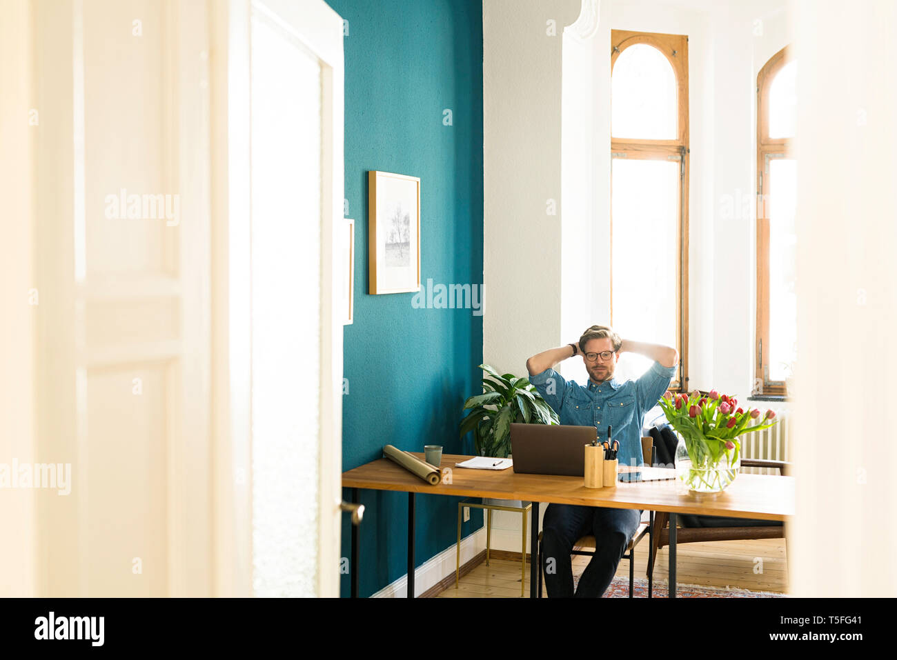 Casual businessman in home office working at his laptop Stock Photo