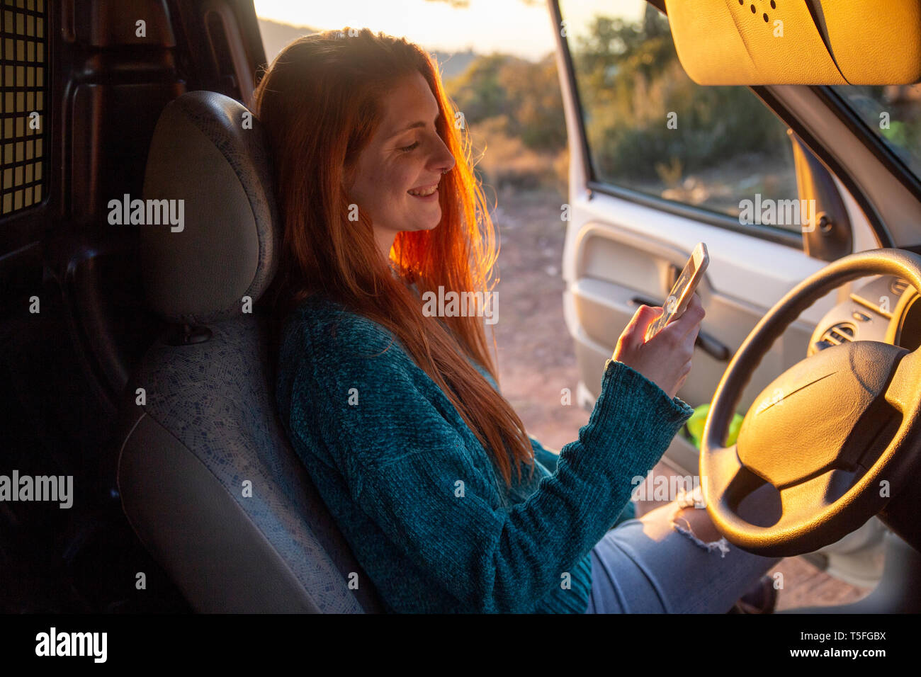 Young woman on a road trip, using smartphone Stock Photo