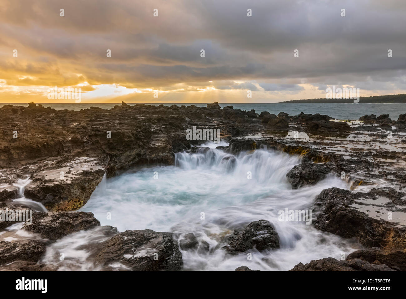 USA, Hawaii, Kauai, Pacific Ocean, North Coast, Blowhole, Sink hole at sunset Stock Photo