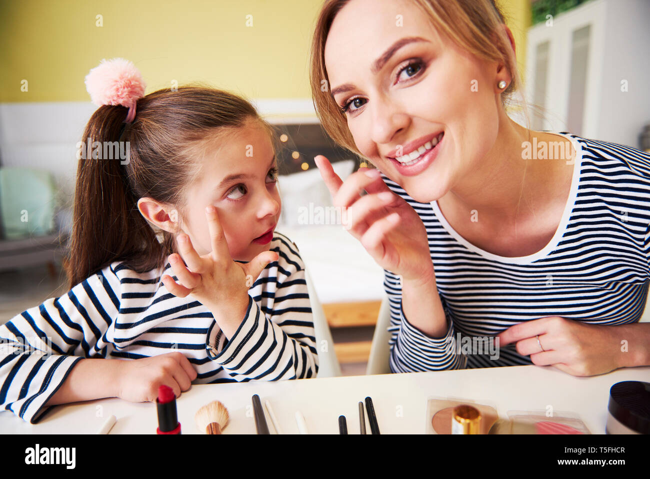 Mother and daughter applying make up together Stock Photo
